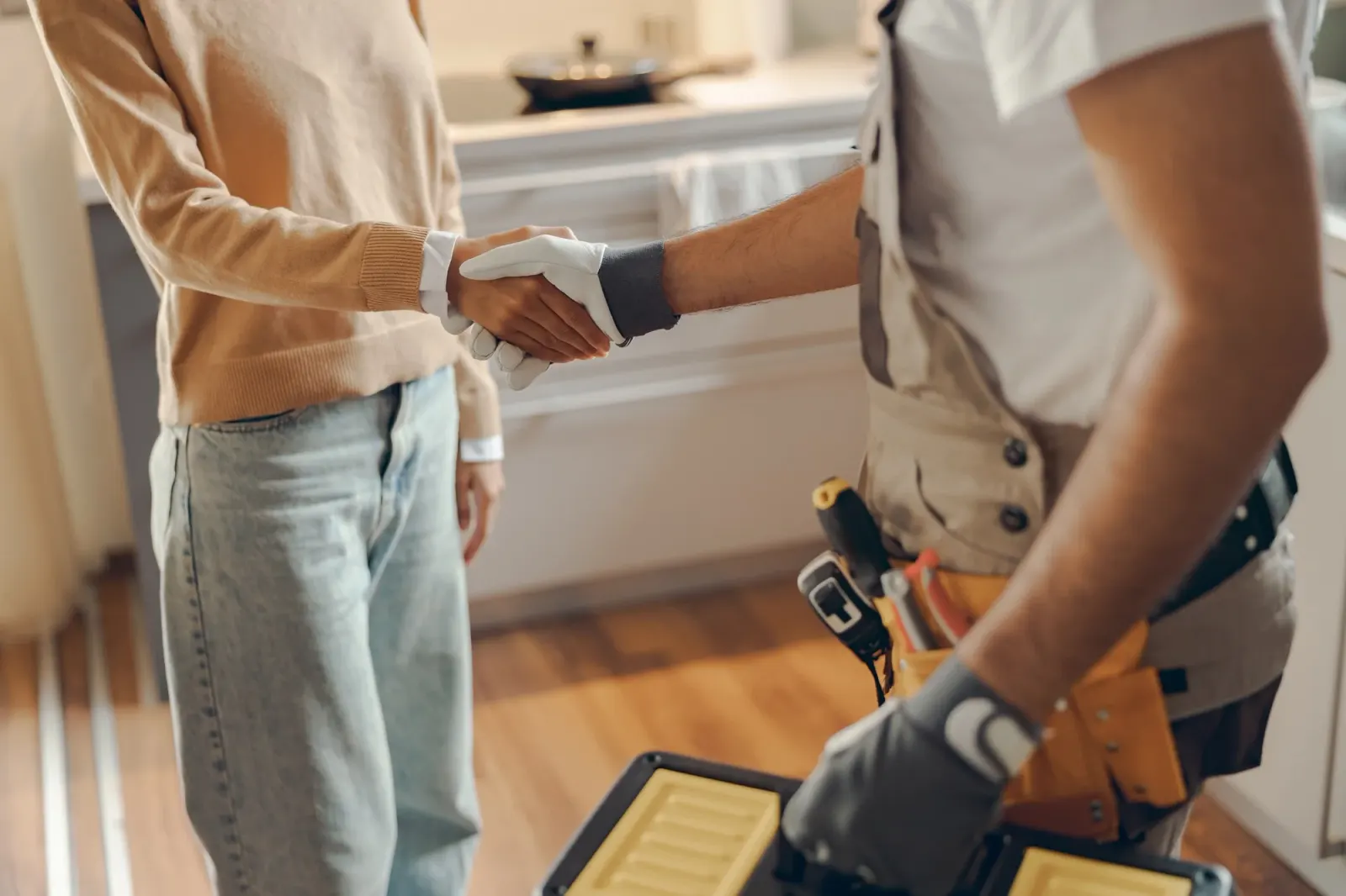 Plumber shaking hands with a client after agreeing the scope of work