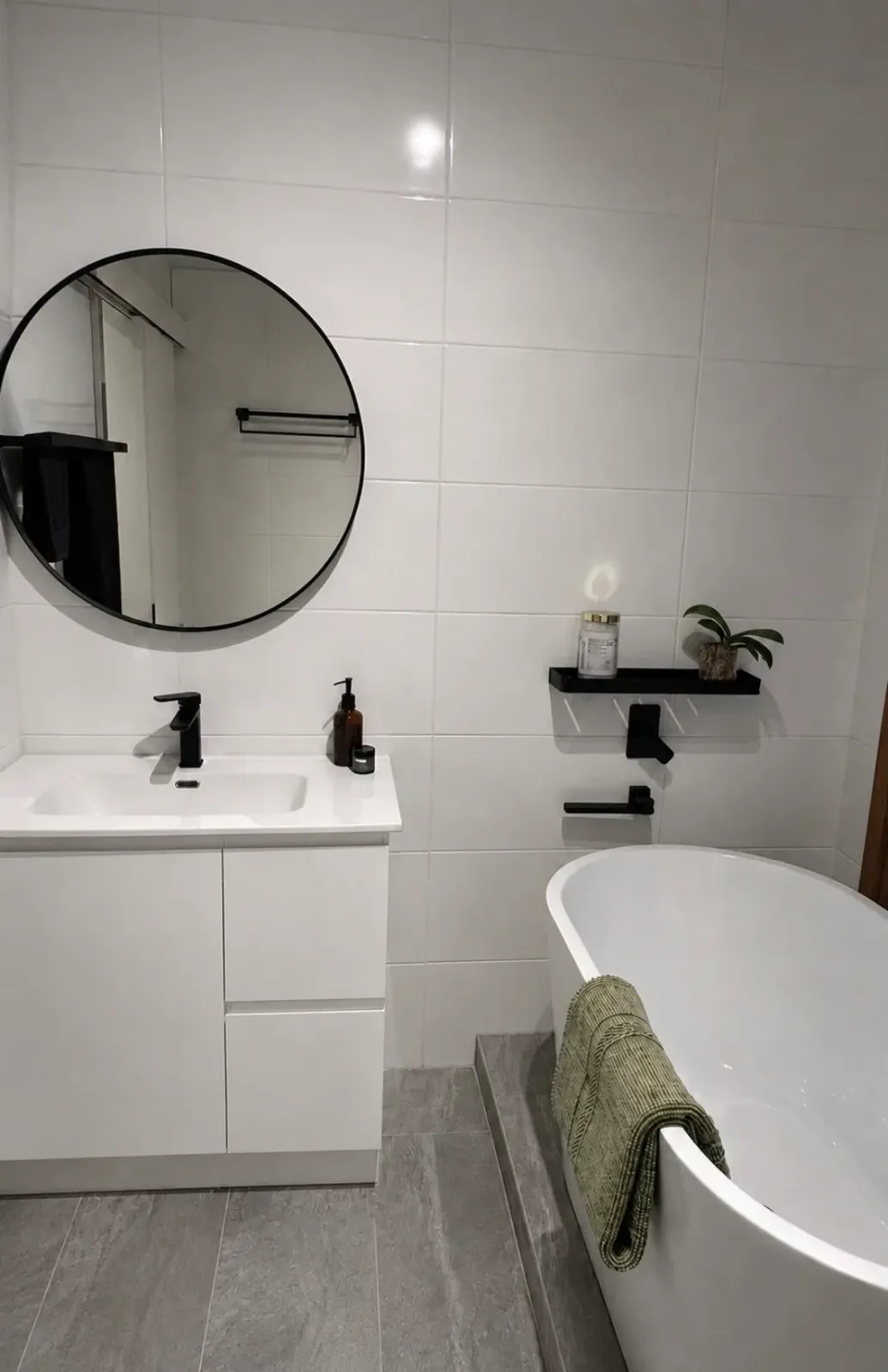 Renovated bathroom with black tapware and a freestanding bath